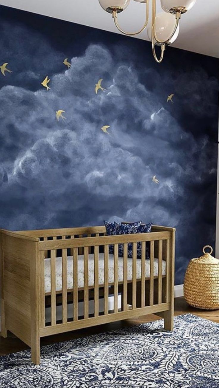 a baby's room with a crib and wall mural