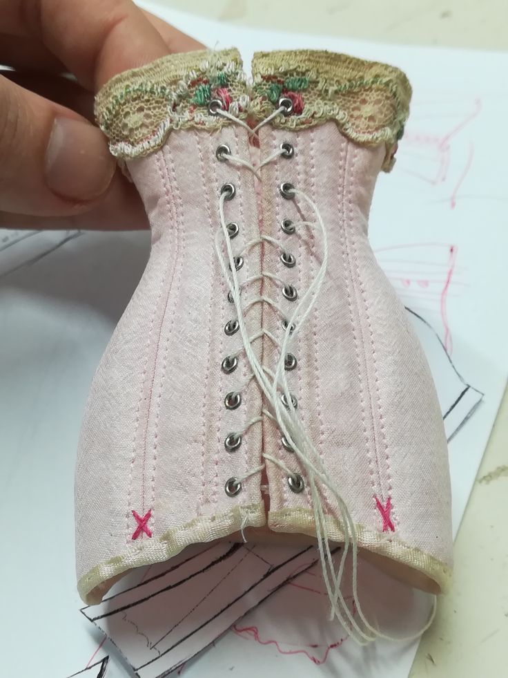 a pink corset is being stitched together