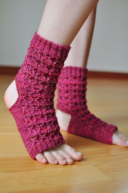 a woman's feet wearing pink knitted slippers and barefoot sandals on a wooden floor