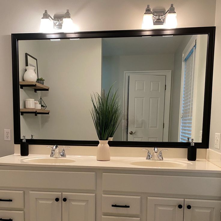 a bathroom with two sinks and a large mirror