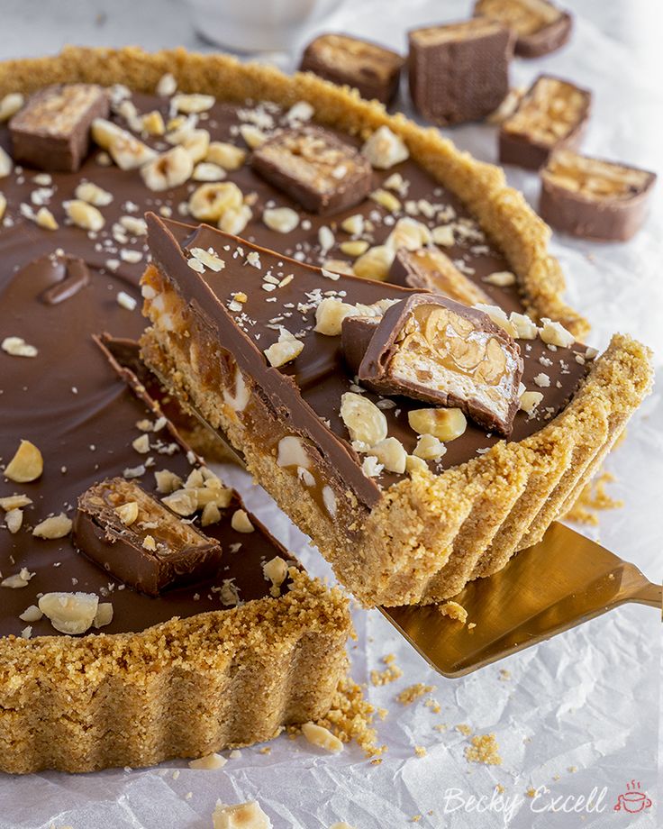 there is a chocolate pie with nuts on the top and one slice missing from it