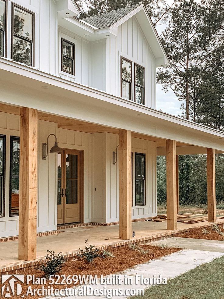 a white house with wooden pillars and windows