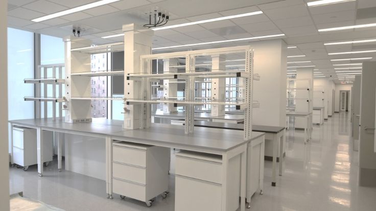 an empty laboratory with white cabinets and shelves