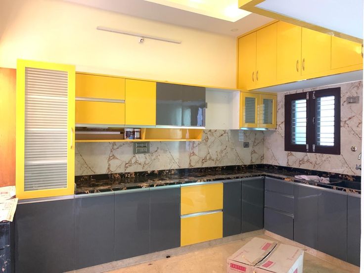 a kitchen with yellow cabinets and marble counter tops in the process of remodeling