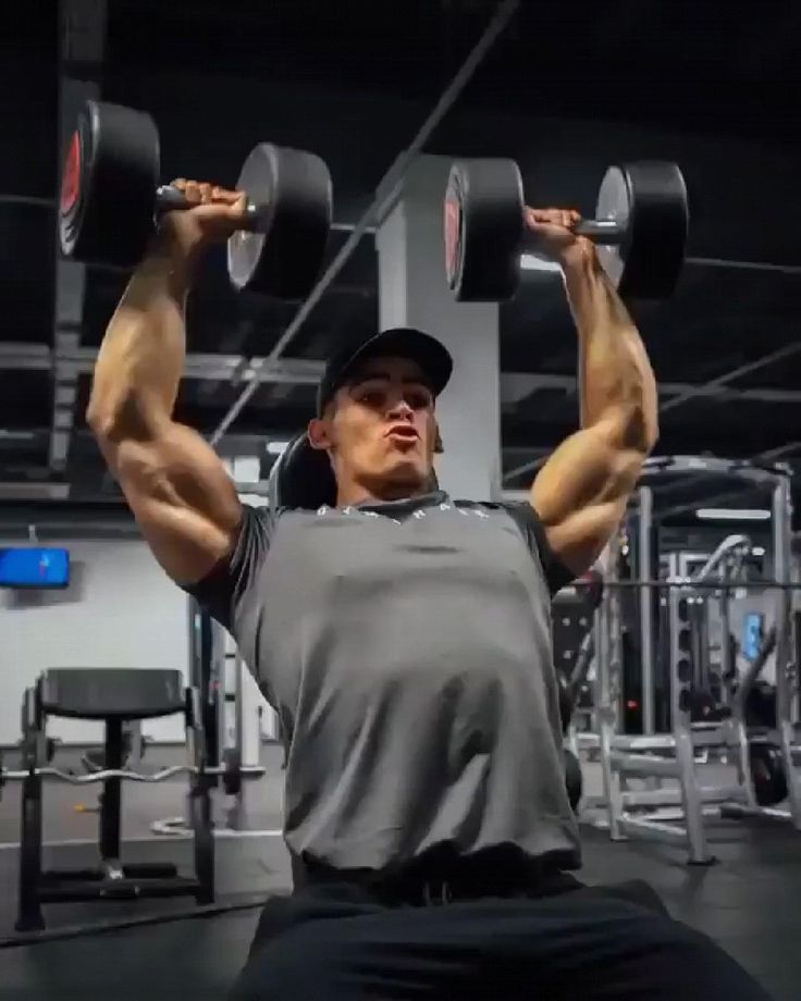 a man is doing exercises with dumbbells in the gym