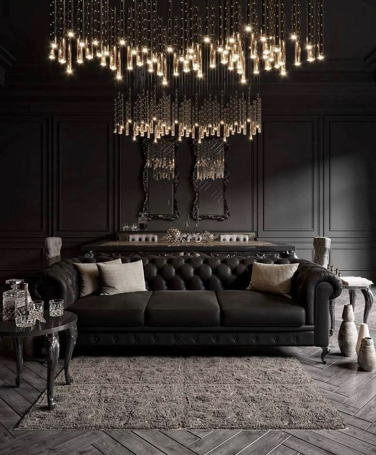 an elegant living room with black leather furniture and chandelier hanging from the ceiling