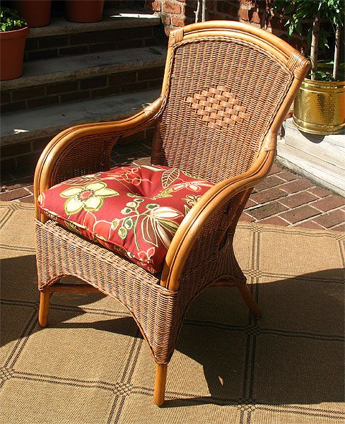 a wicker chair sitting on top of a patio next to a potted plant