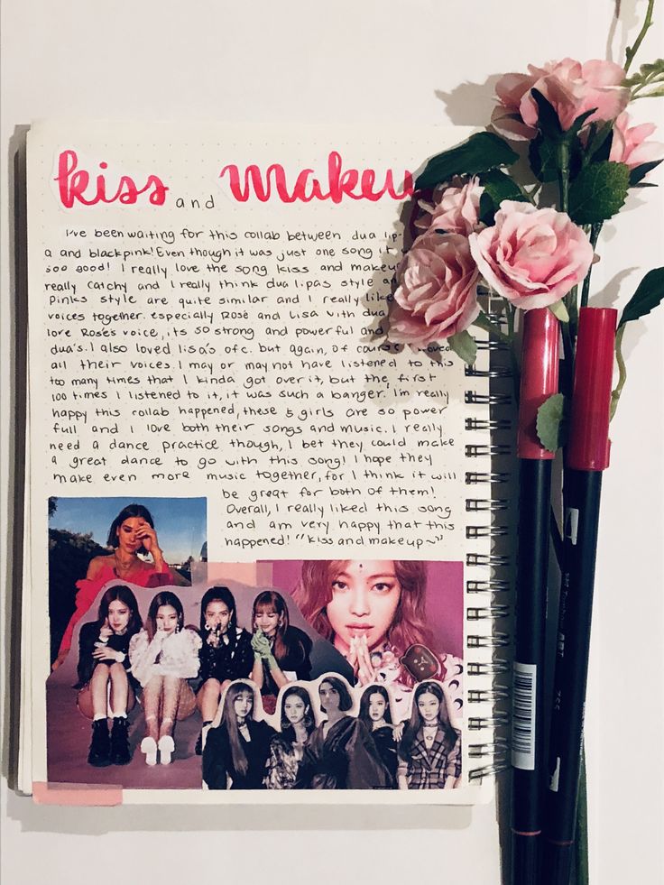 an open notebook with photos and flowers on it next to a pen that says kiss and makeup