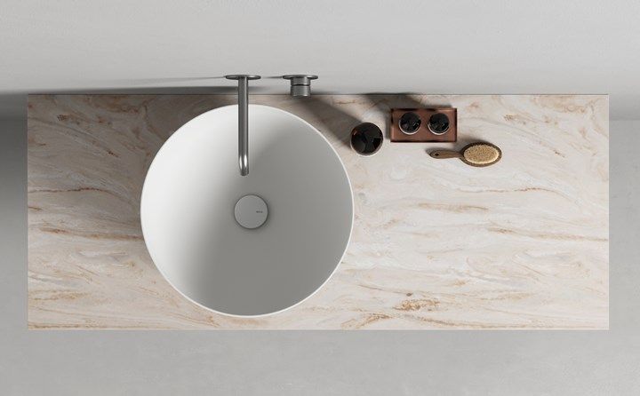 a white sink sitting on top of a counter next to a wall mounted faucet