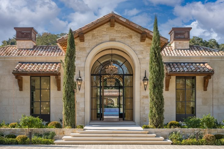 the front entrance to a large home with stone steps leading up to it's entry