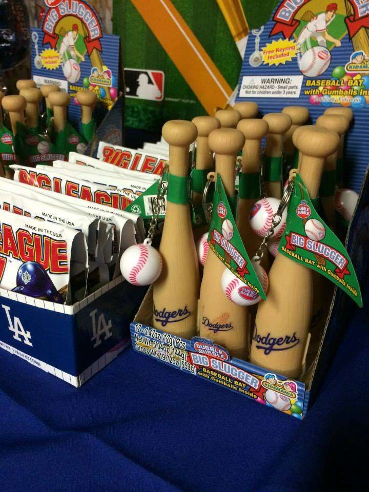 baseball themed party favors are displayed on a blue tablecloth with white and green trim