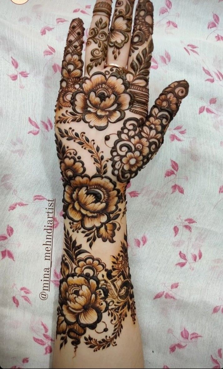 the hand is decorated with flowers and leaves