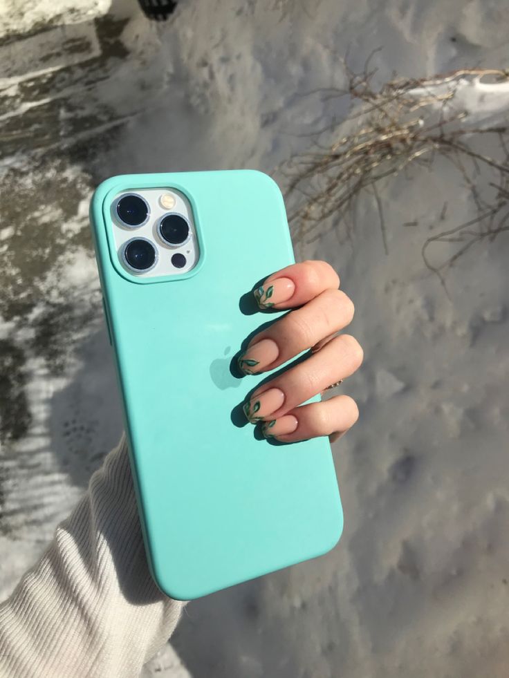 a woman's hand holding an iphone case with green nail polish on her nails