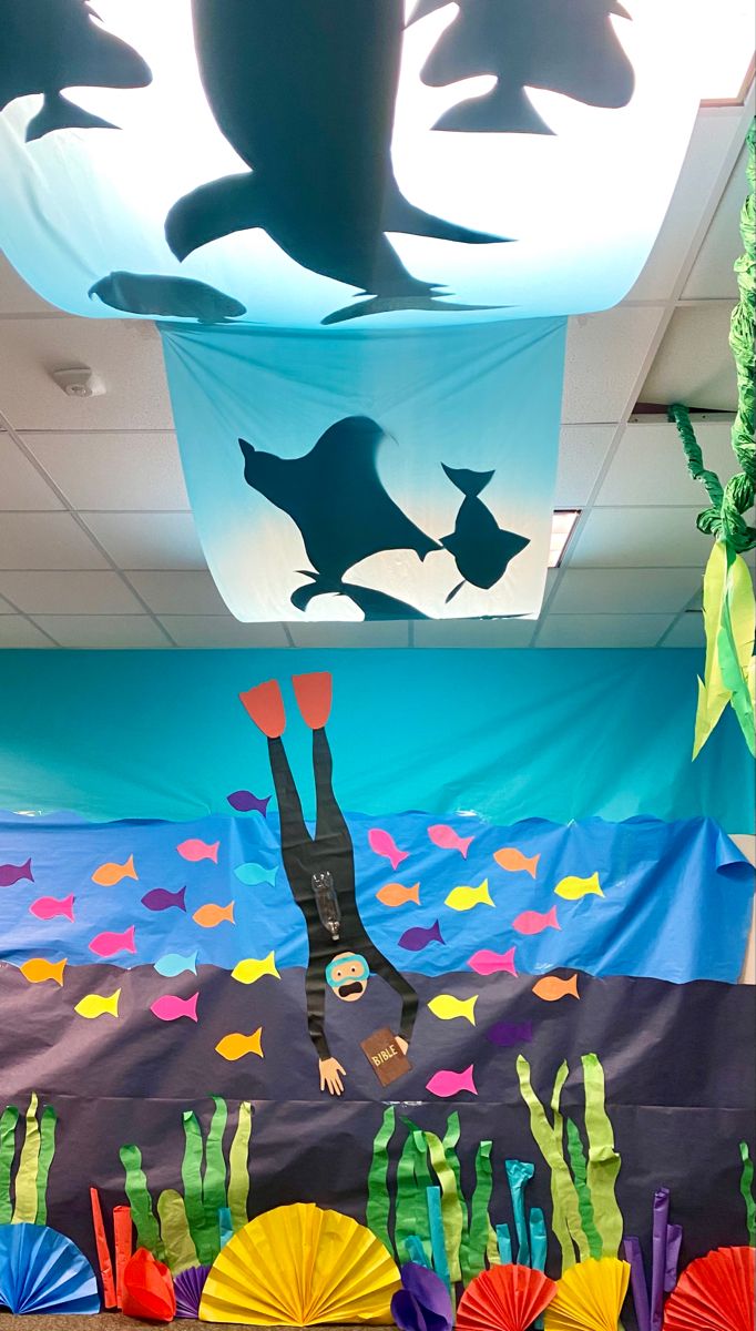 an ocean themed classroom decoration with under the sea theme and paper umbrellas on the floor