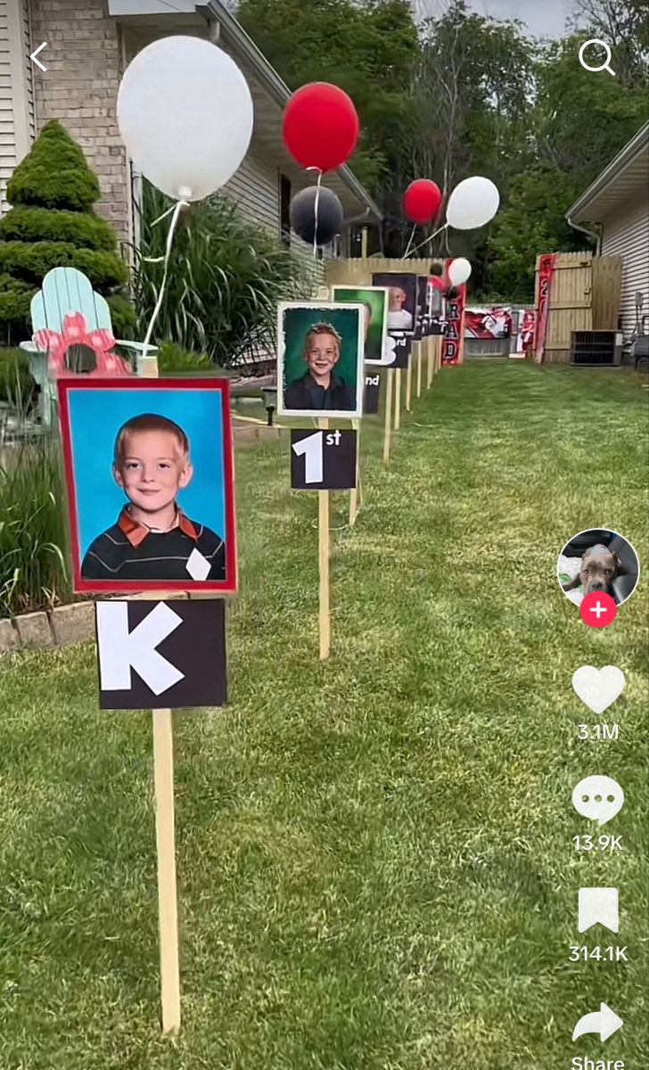 several yard signs with photos and balloons in the back ground, along with an image of a young boy