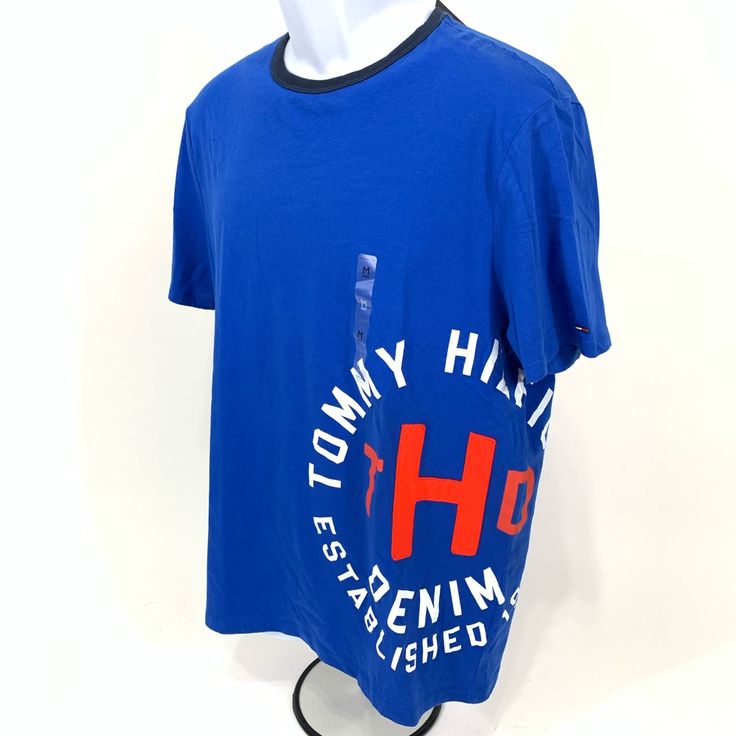 Tommy Hilfiger Denim T-Shirt. Nwt. Medium. Bought For Son Who Had A Major Growth Spurt And Never Got To Wear It. Pet And Smoke Free Home. Trendy Denim Blue Crew Neck Top, Trendy Denim Crew Neck Top, Denim Blue Cotton Crew Neck Top, Denim Crew Neck Top For Streetwear, Denim Blue Cotton Short Sleeve Top, Blue Shirt With Text Print For Spring, Denim Short Sleeve T-shirt For Spring, Denim Blue Short Sleeve Tops For Streetwear, Blue Cotton Tops With Text Print