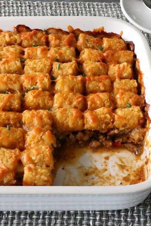 a casserole dish filled with tater tots on top of a table