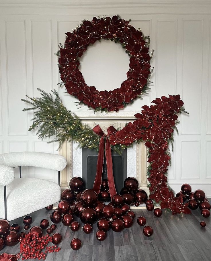 a room with christmas decorations and balls on the floor next to a fire place in front of a wreath