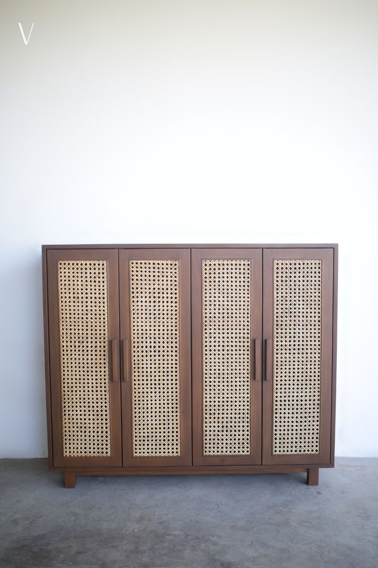 a wooden cabinet with wicker doors on the front and sides, against a white wall