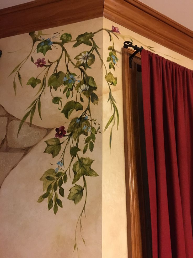 a painting on the side of a wall next to a window with red drapes