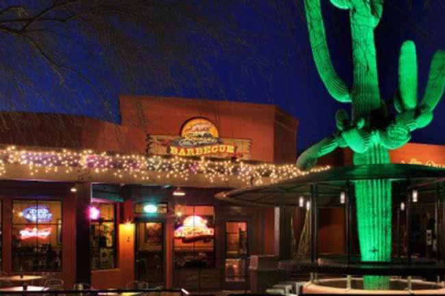 a large cactus sitting on top of a table in front of a restaurant at night