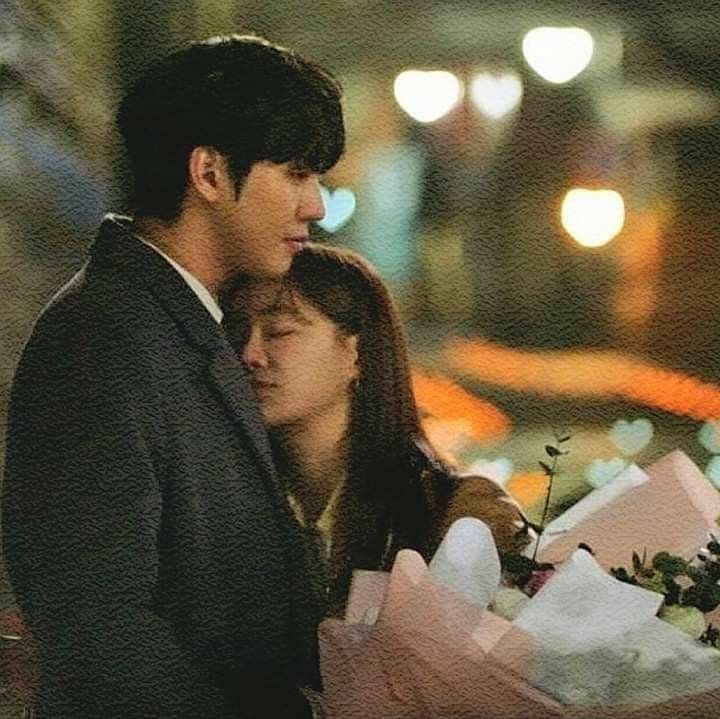 a man and woman standing next to each other holding flowers