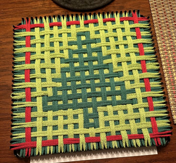 a close up of a piece of cloth on top of a wooden table next to a hat