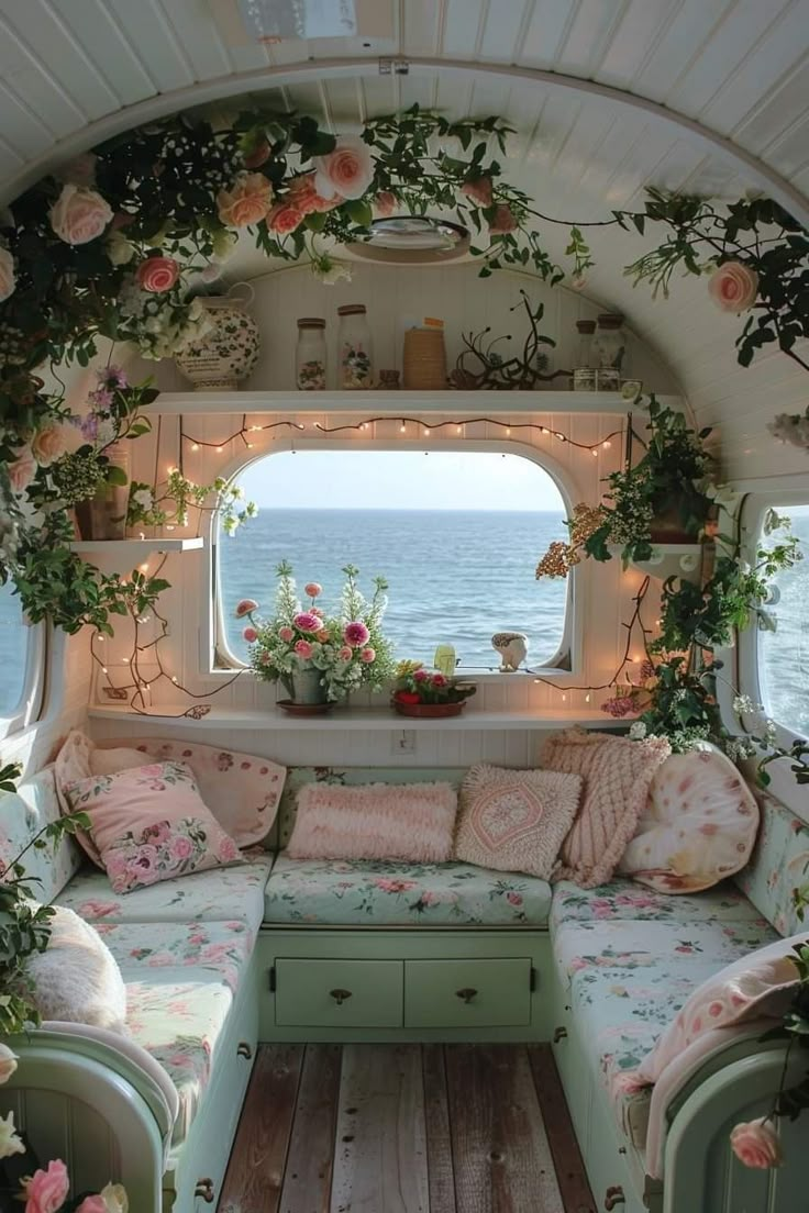 a living room filled with lots of furniture and flowers on the window sill,