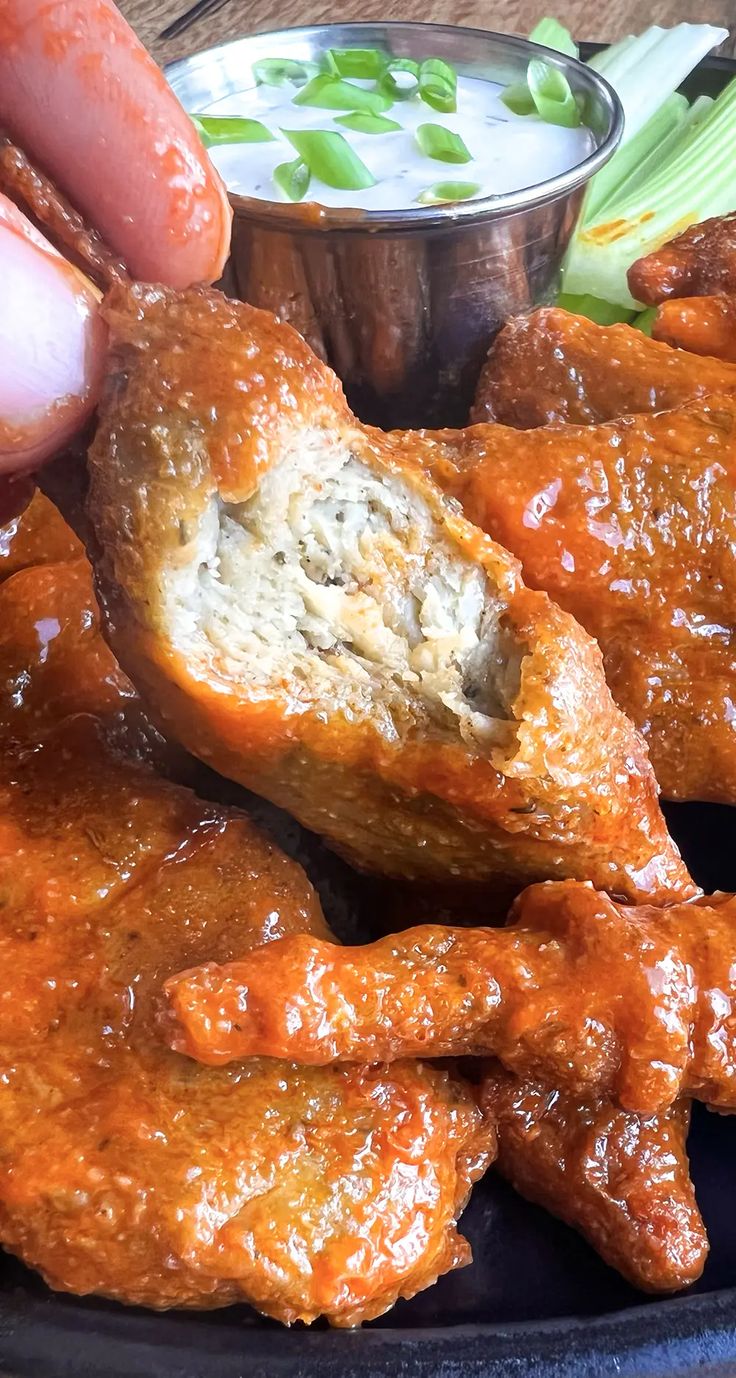 a plate full of wings and dipping sauce