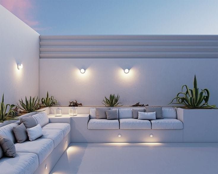 a living room with white couches and potted plants on the wall next to it