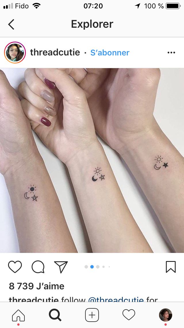 two people holding hands with small tattoos on their arms and one has a sun, moon and stars tattoo on the wrist