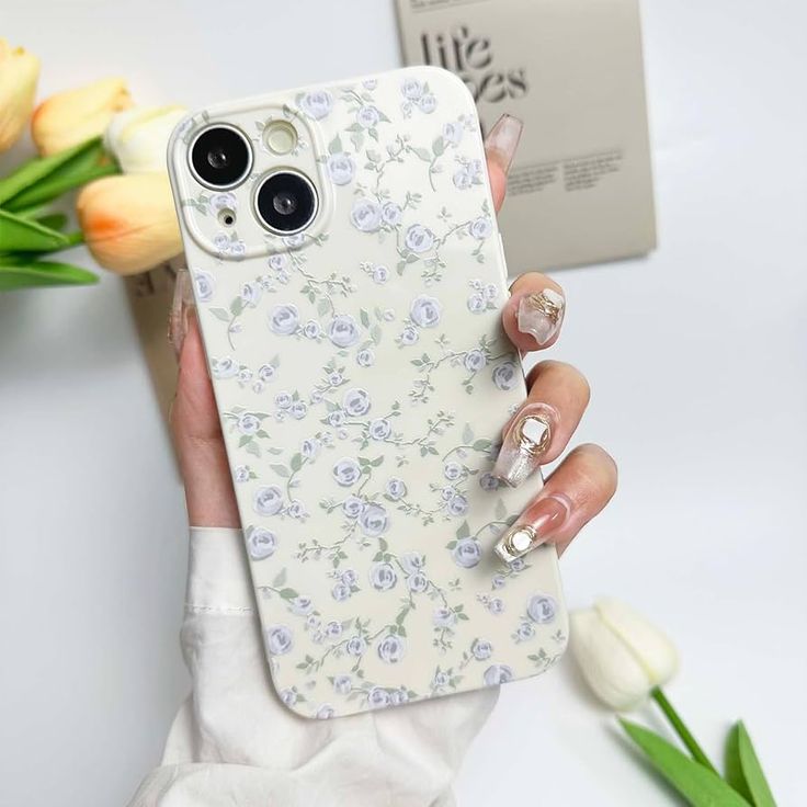 a woman's hand holding an iphone case with flowers on it