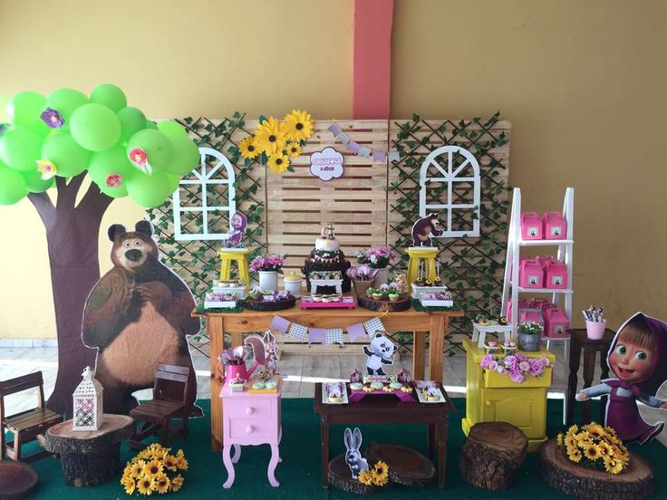 there are many decorations on the table for this birthday party that is decorated in pink, yellow and green