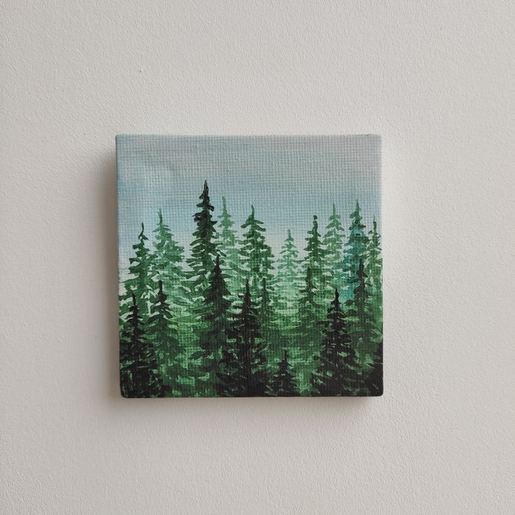 an acrylic painting of pine trees on a canvas mounted to a wall in a white walled room