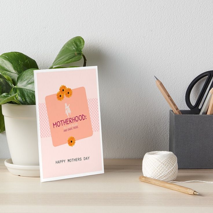 a mother's day card on a desk next to a potted plant art board print