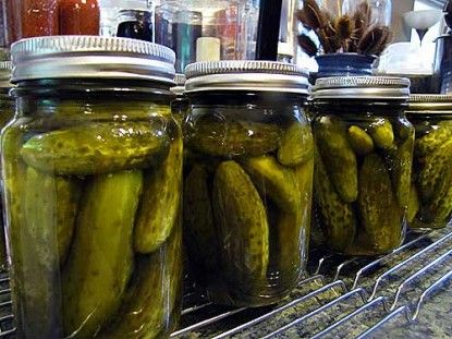 jars filled with pickles sitting on top of a counter