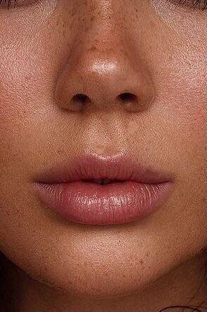 a woman's face with freckles on her cheeks and nose, close up