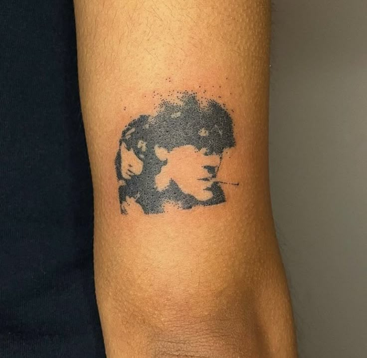 a man's arm with a tattoo of two people on the left side of his arm