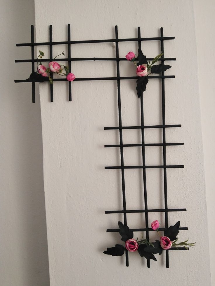 the wall is decorated with black and pink flowers, which are attached to metal bars