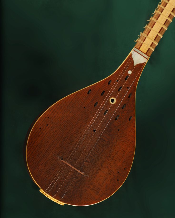 an overhead view of a wooden instrument on the water's edge with green background