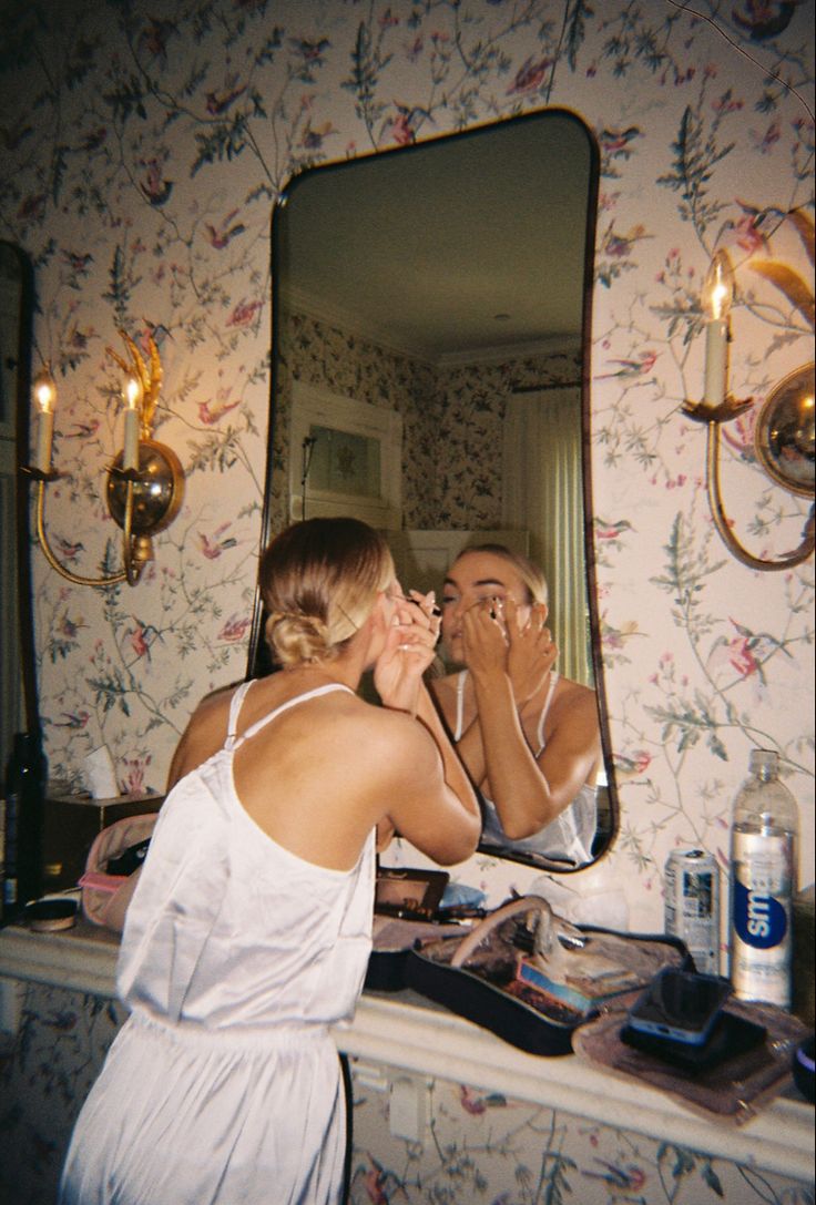 a woman is brushing her teeth in front of a mirror