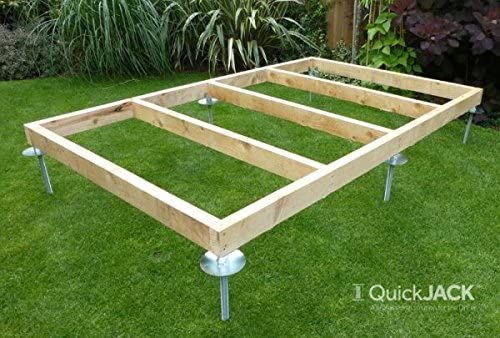 a bed frame sitting on top of green grass in the middle of a yard with metal legs