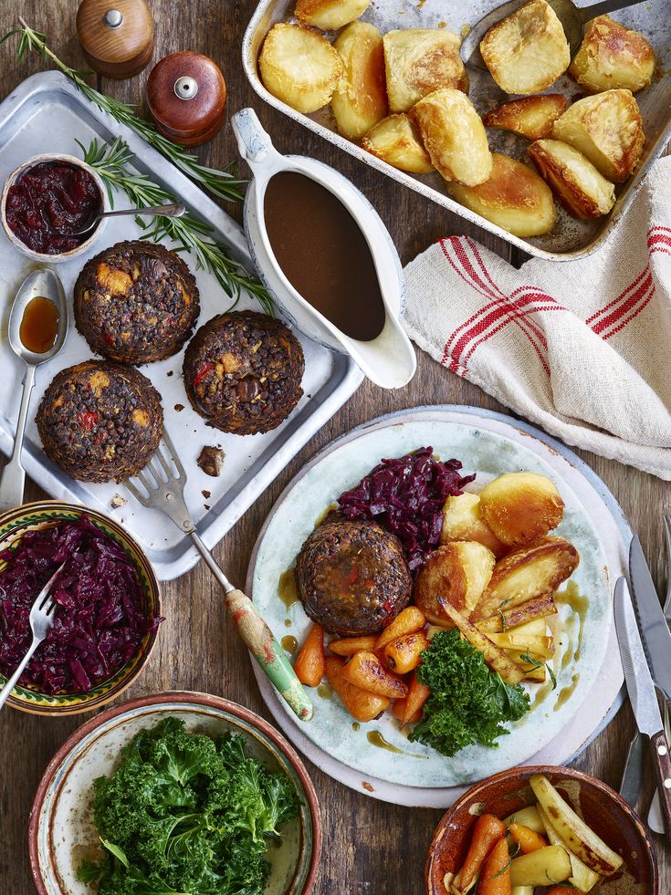 a table topped with plates and bowls filled with food next to other dishes on top of a wooden table