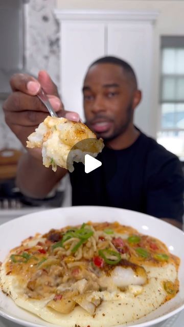 a man eating food from a white plate on top of a table with a knife and fork in his hand