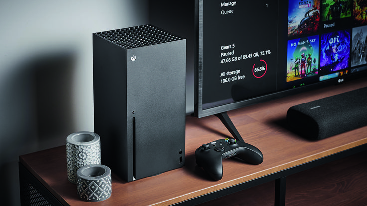 a desk with a monitor, game controller and speakers on it