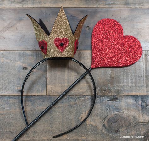 two heart shaped crowns sitting on top of a wooden floor next to a wire headband