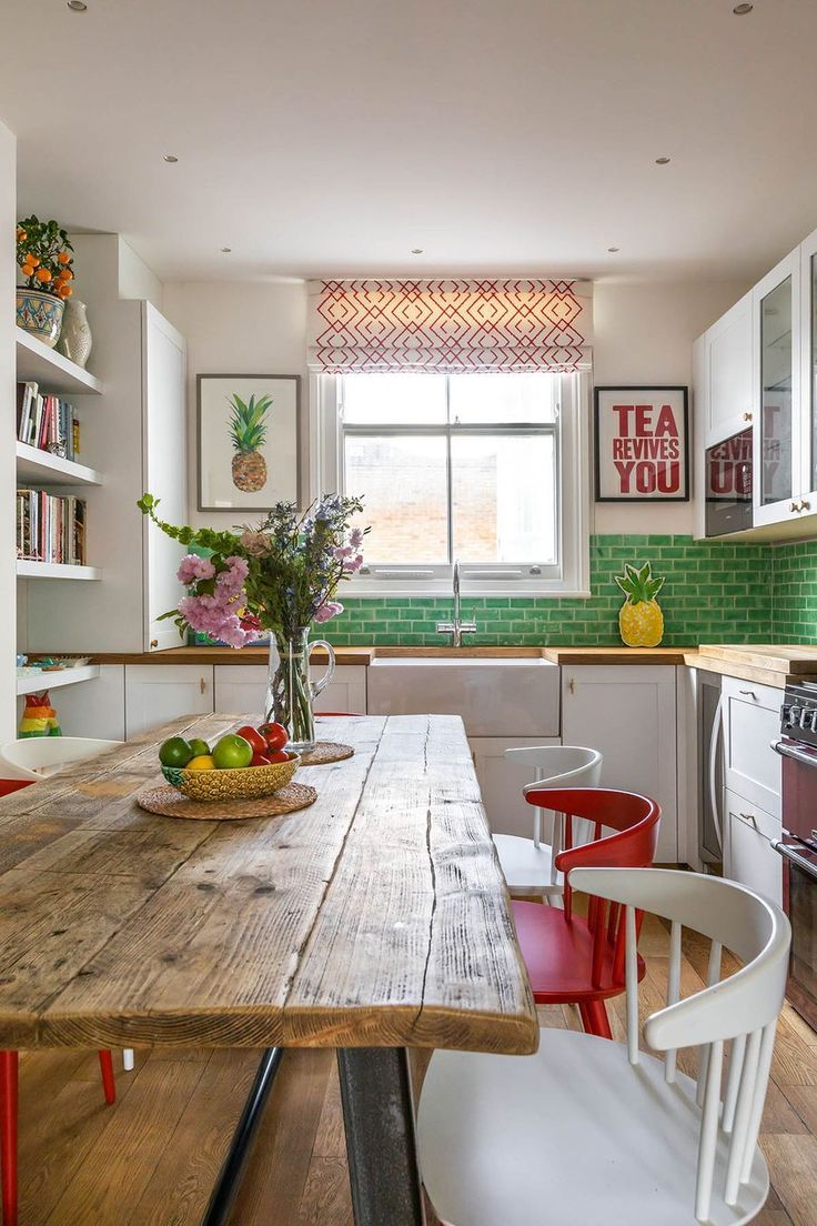 a wooden table sitting in the middle of a kitchen next to a stove top oven