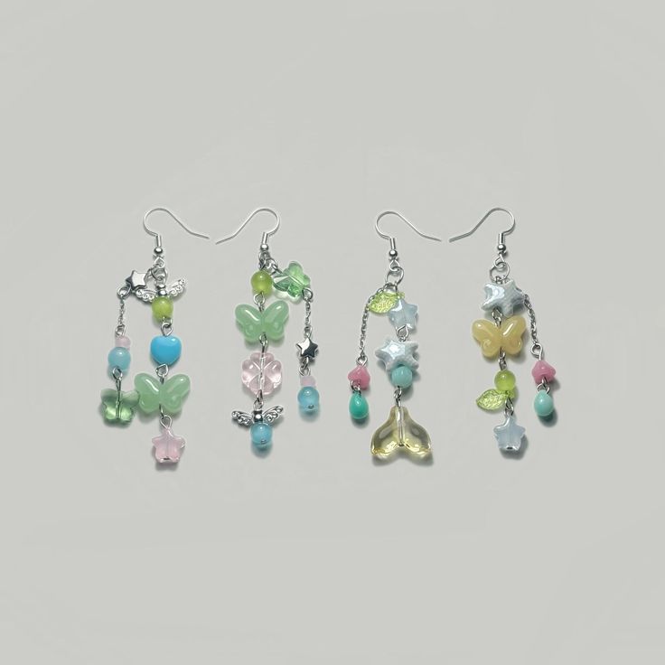 three pairs of dangling earrings with flowers and butterflies on them, all in different colors