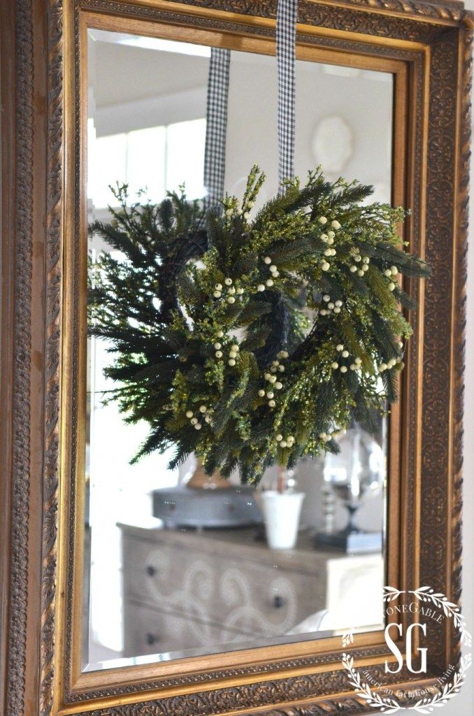 a mirror with a wreath hanging on it