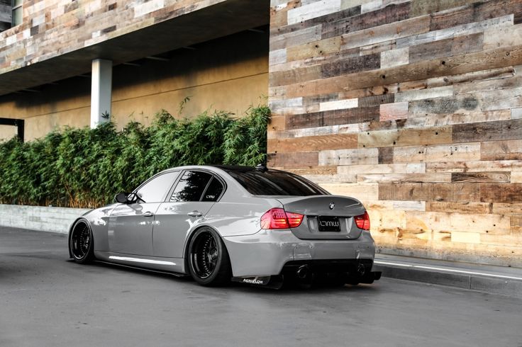 a silver car parked in front of a building next to a planter filled with flowers